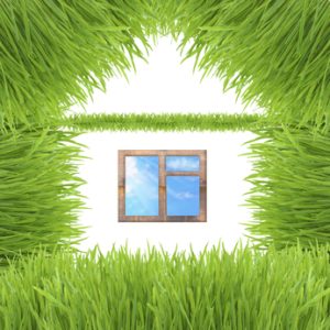 Conceptual green grass house isolated on white